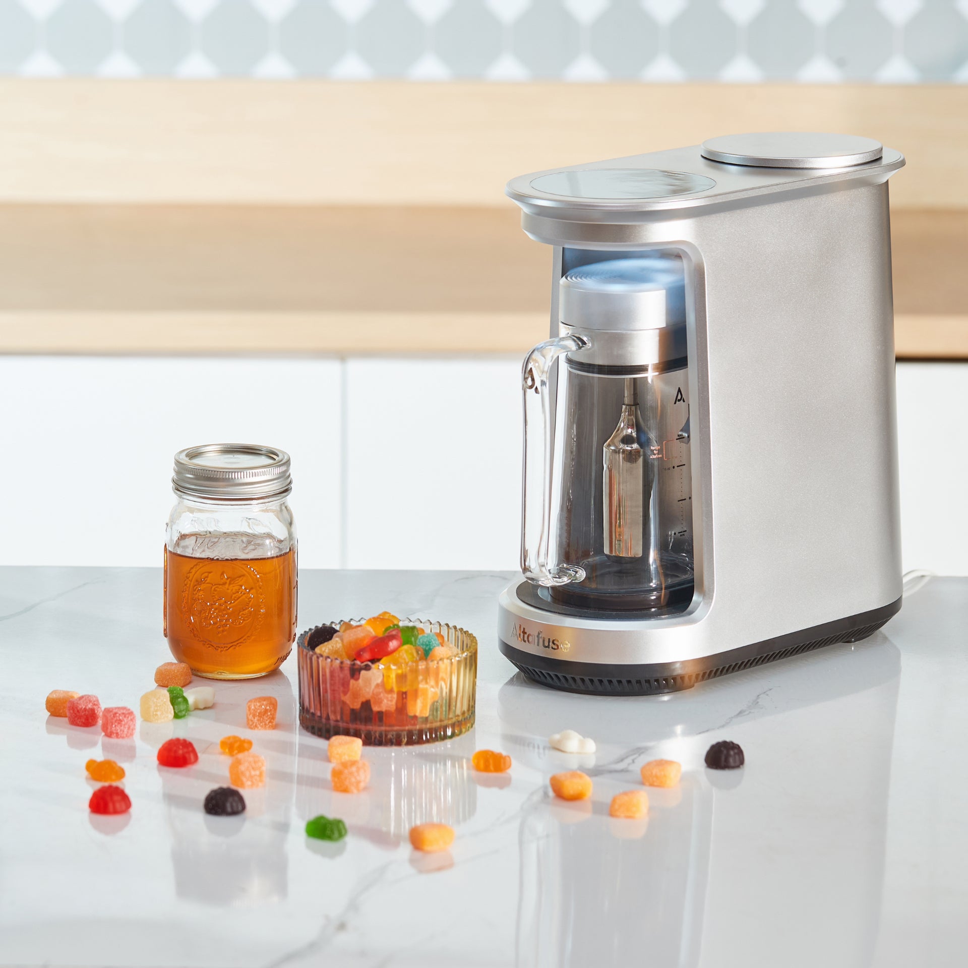 ALTA 1 Ultrasonic Infuser displayed on a kitchen counter alongside Gummy Mix, demonstrating its ability to create flavorful gummies with ease.